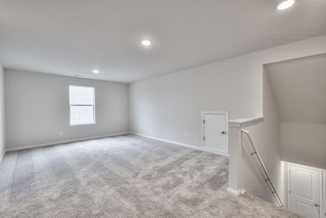 empty room with light colored carpet and lofted ceiling