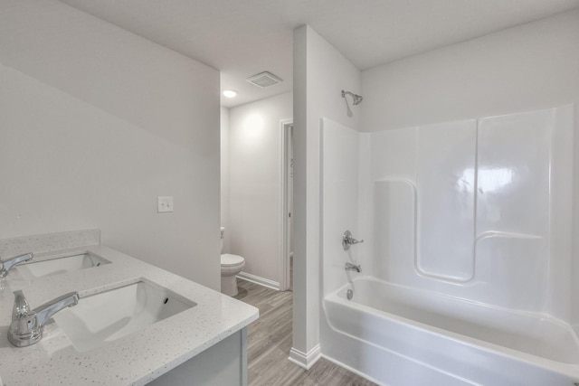 full bathroom with bathing tub / shower combination, hardwood / wood-style floors, vanity, and toilet