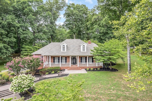 cape cod home featuring covered porch and a front lawn