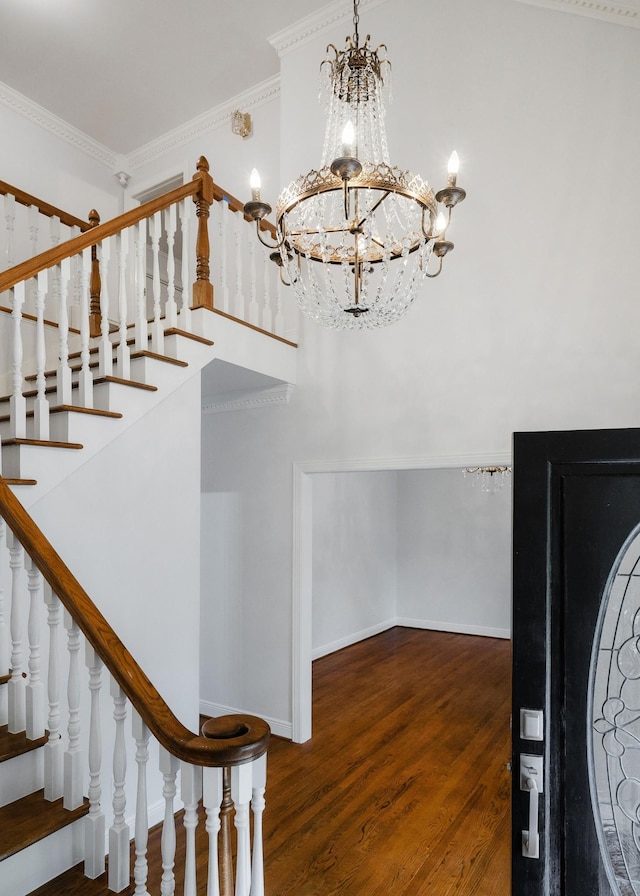 entrance foyer featuring dark hardwood / wood-style floors, crown molding, and a notable chandelier