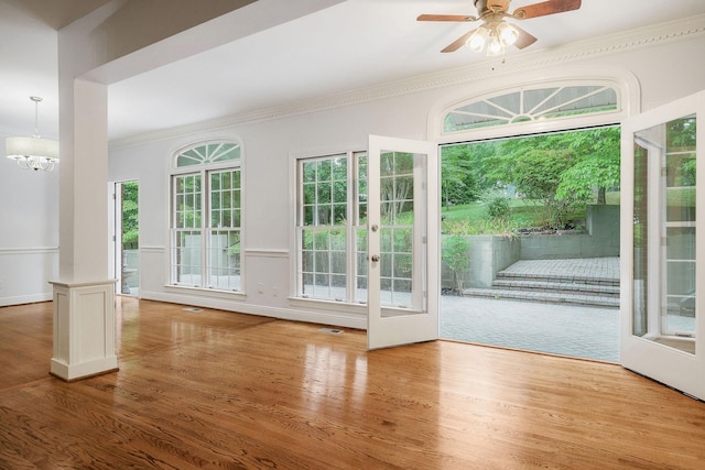 entryway featuring french doors, ceiling fan with notable chandelier, light hardwood / wood-style flooring, and ornamental molding