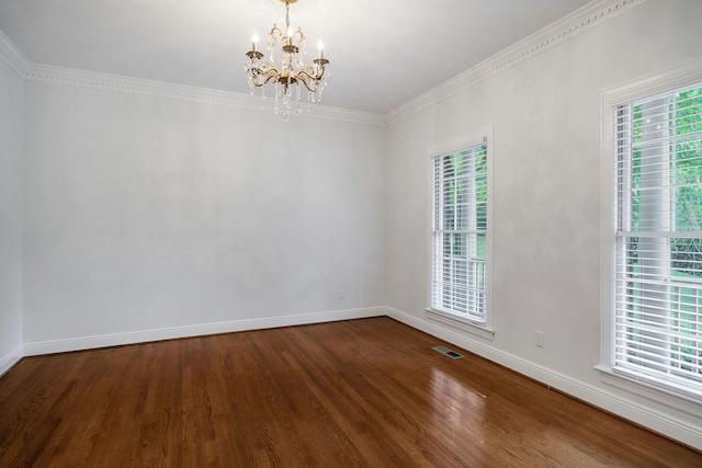 unfurnished room featuring hardwood / wood-style floors, plenty of natural light, crown molding, and an inviting chandelier