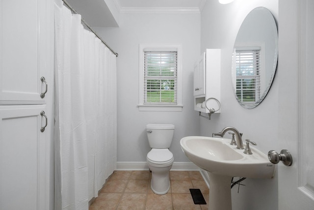 bathroom featuring tile patterned flooring, toilet, and crown molding