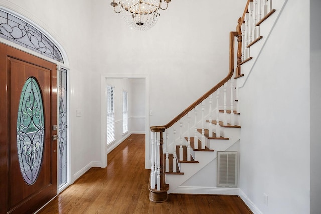 foyer entrance featuring a chandelier, a high ceiling, and hardwood / wood-style flooring