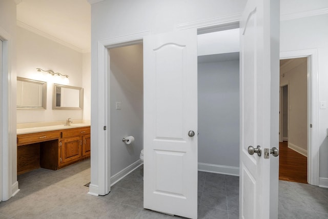 bathroom with tile patterned flooring, toilet, vanity, and ornamental molding