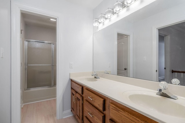 bathroom featuring combined bath / shower with glass door, vanity, and hardwood / wood-style flooring