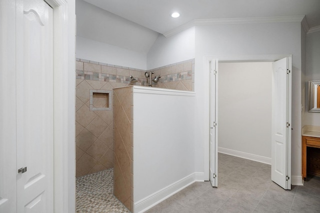 bathroom with tile patterned flooring, a tile shower, vaulted ceiling, and ornamental molding