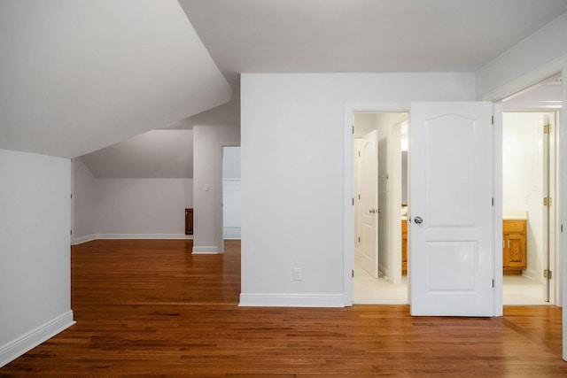 additional living space with hardwood / wood-style floors and lofted ceiling