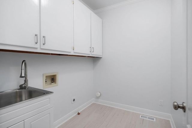 laundry room featuring sink, cabinets, washer hookup, light hardwood / wood-style flooring, and ornamental molding