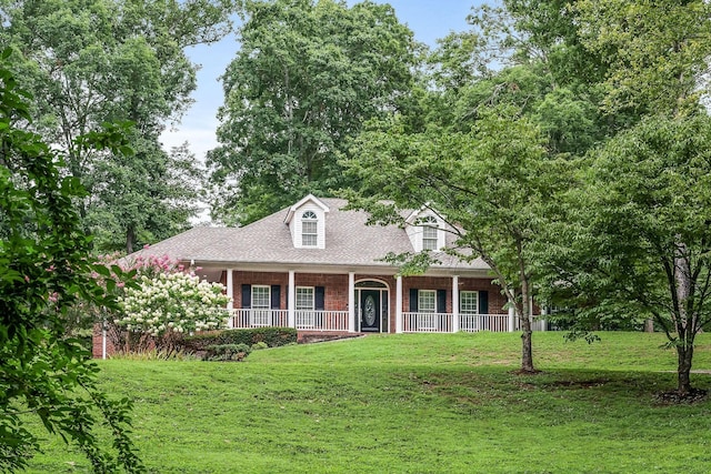 new england style home with a porch and a front lawn