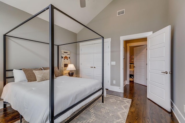 bedroom with ceiling fan, a closet, high vaulted ceiling, and dark wood-type flooring