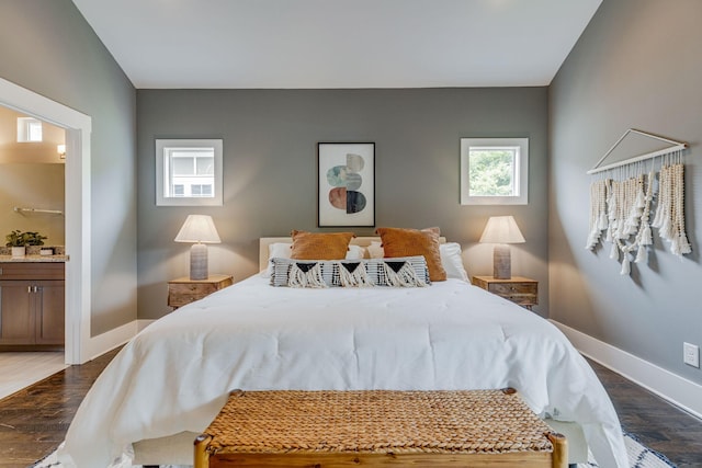 bedroom featuring ensuite bathroom and dark wood-type flooring