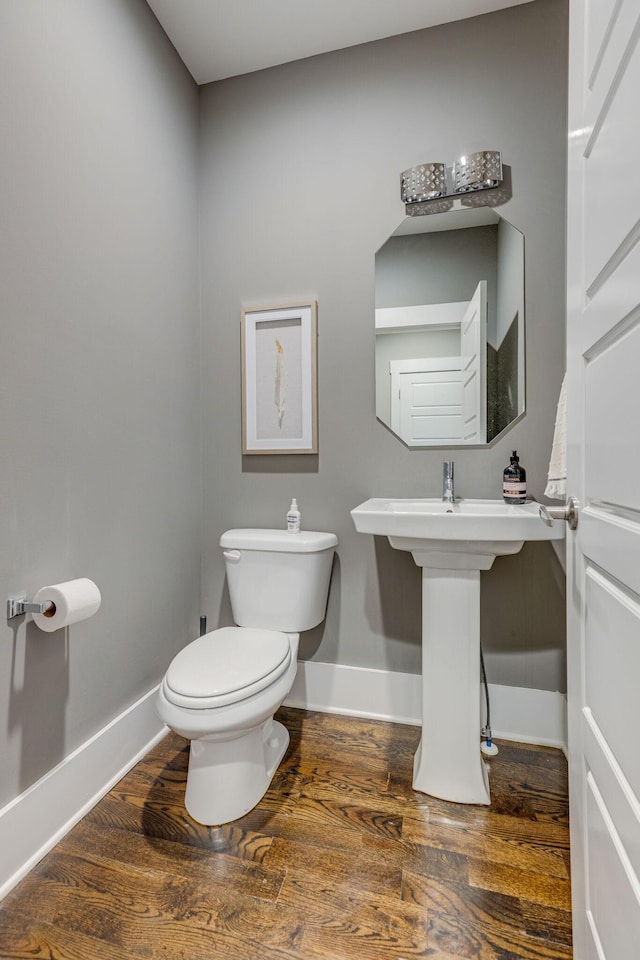 bathroom with hardwood / wood-style flooring, toilet, and sink