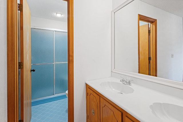 bathroom with vanity, a textured ceiling, toilet, and an enclosed shower