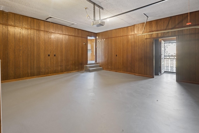 garage with wood walls and a garage door opener