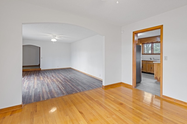 spare room with ceiling fan, light hardwood / wood-style floors, and a textured ceiling