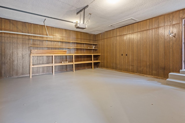 garage with wood walls and a garage door opener