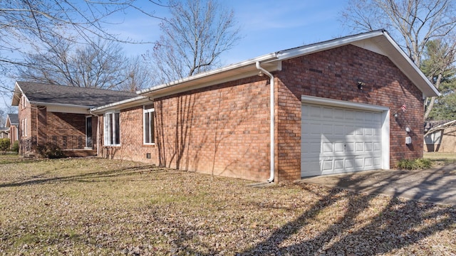 view of side of home featuring a garage and a lawn