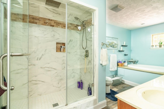 bathroom with hardwood / wood-style flooring, vanity, toilet, and a shower with shower door