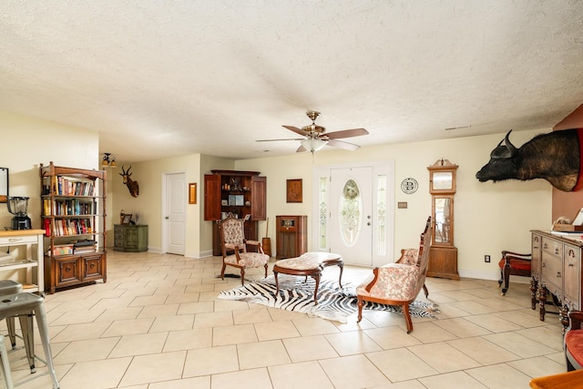 living room featuring light tile patterned floors, a textured ceiling, and ceiling fan