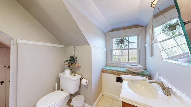 bathroom with tile patterned floors, vanity, toilet, and lofted ceiling