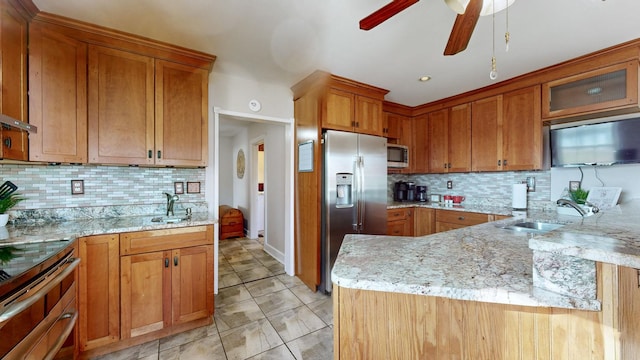 kitchen with decorative backsplash, light stone countertops, sink, and stainless steel appliances