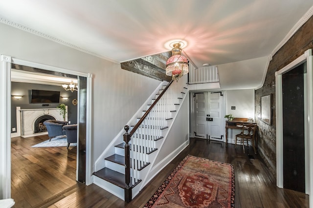 stairs with hardwood / wood-style floors and an inviting chandelier