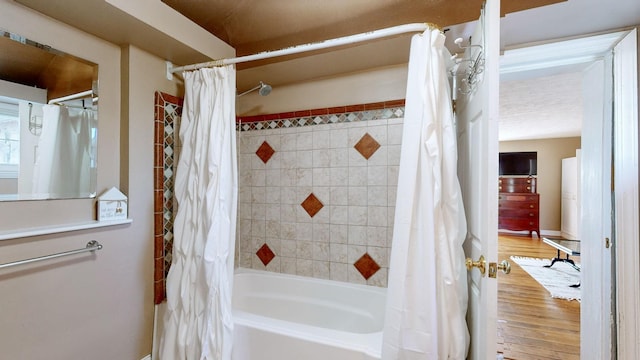 bathroom with hardwood / wood-style flooring and shower / tub combo