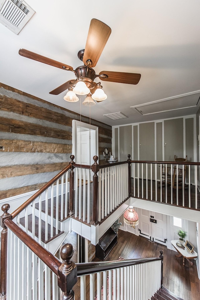 stairway with wood-type flooring and ceiling fan