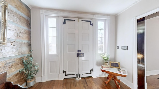 entryway featuring hardwood / wood-style floors and crown molding