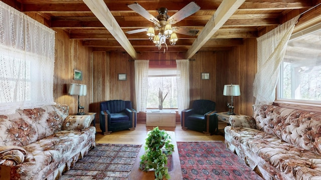 living room featuring beamed ceiling, wood walls, light hardwood / wood-style floors, and wooden ceiling