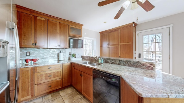 kitchen with kitchen peninsula, light stone countertops, backsplash, sink, and dishwasher