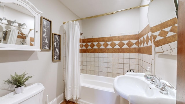 full bathroom with toilet, shower / bathtub combination with curtain, and sink