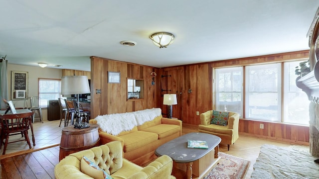 living room featuring wooden walls and light hardwood / wood-style floors