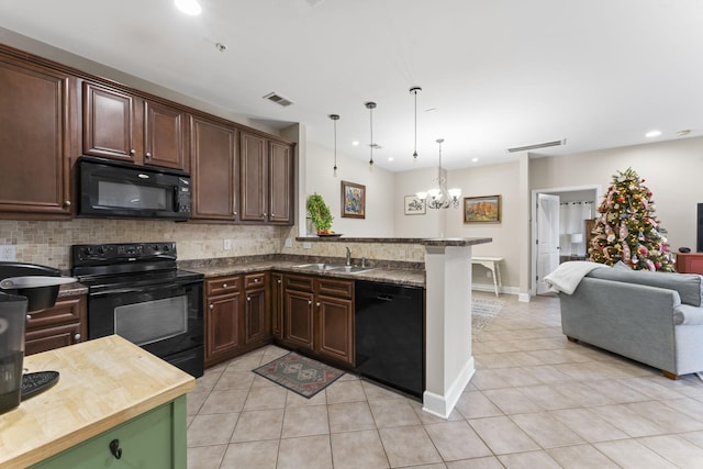 kitchen featuring hanging light fixtures, an inviting chandelier, tasteful backsplash, dark stone countertops, and black appliances