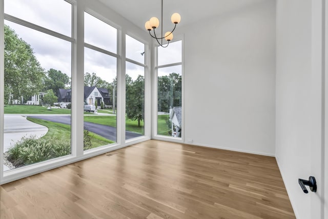 unfurnished sunroom with a healthy amount of sunlight and a chandelier