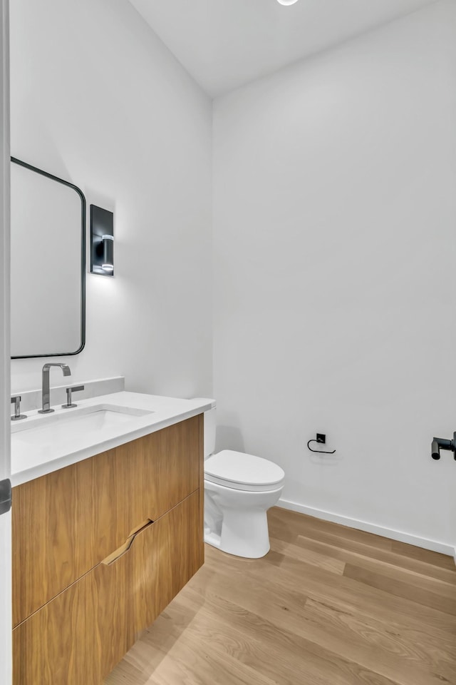 bathroom featuring hardwood / wood-style floors, vanity, and toilet