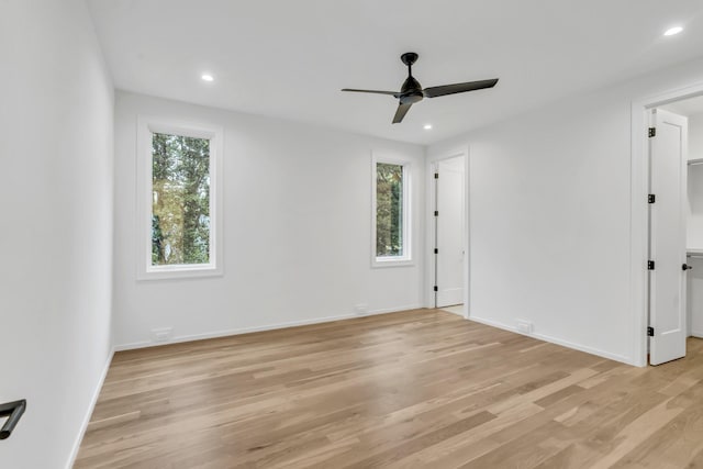 empty room with ceiling fan and light hardwood / wood-style floors