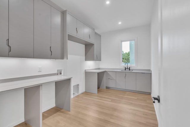 kitchen with gray cabinetry, light hardwood / wood-style flooring, and sink