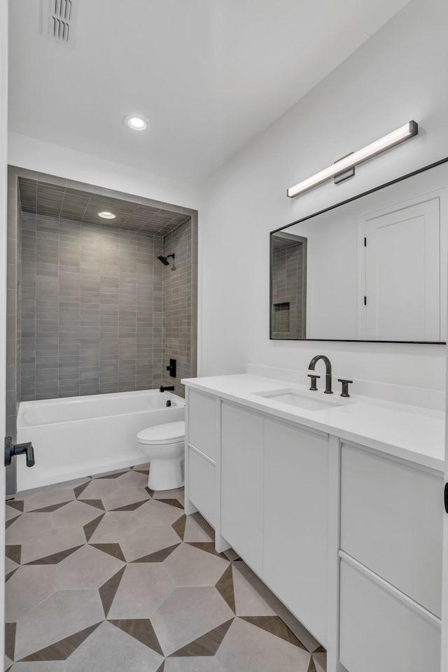 full bathroom featuring toilet, tile patterned flooring, vanity, and tiled shower / bath