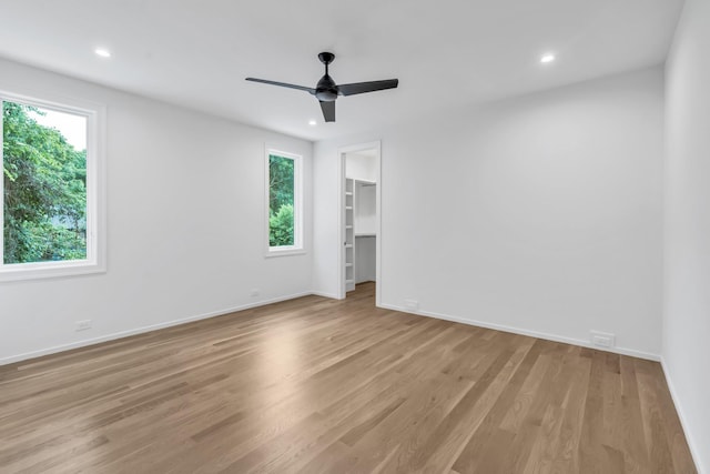 empty room with ceiling fan and light wood-type flooring