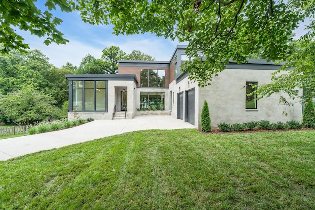 back of house with a garage and a lawn