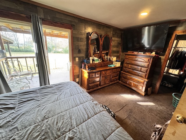 carpeted bedroom featuring access to exterior and wooden walls