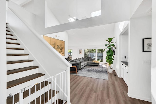 interior space featuring hardwood / wood-style floors, high vaulted ceiling, and ceiling fan