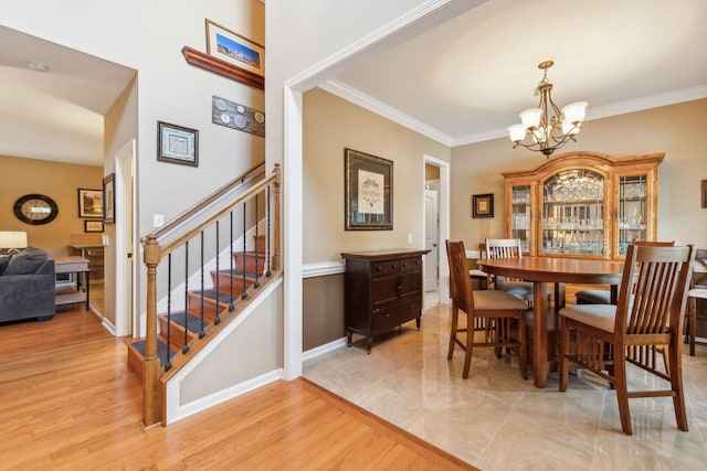 dining area with a notable chandelier, light hardwood / wood-style floors, and ornamental molding