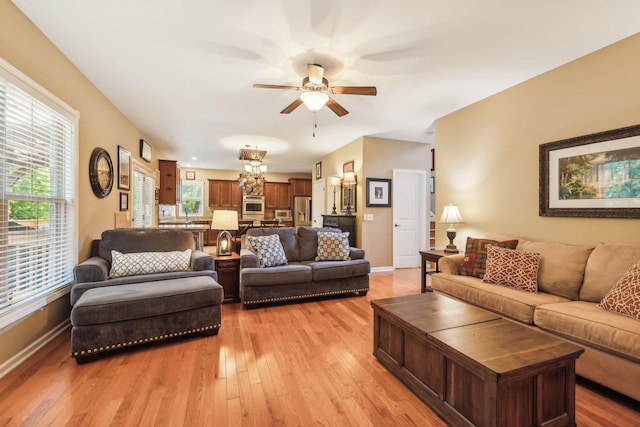 living room featuring ceiling fan, plenty of natural light, and light hardwood / wood-style floors