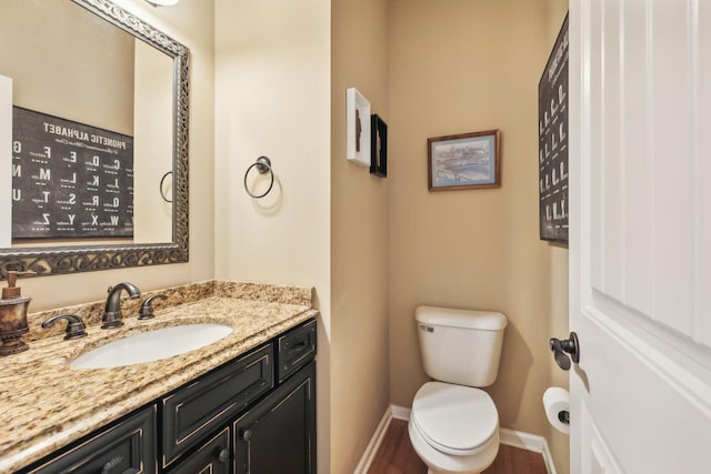 bathroom with wood-type flooring, vanity, and toilet