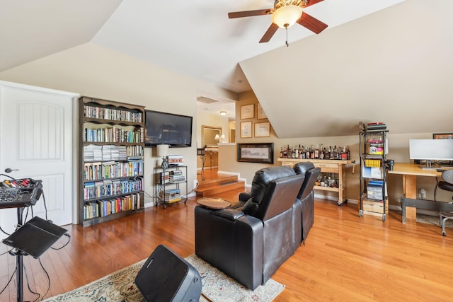 living room with ceiling fan, light hardwood / wood-style floors, and lofted ceiling