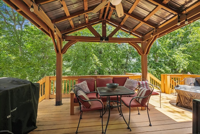 wooden deck with a gazebo, ceiling fan, a grill, and a jacuzzi