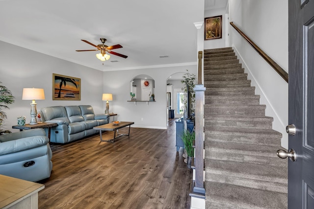 living room with dark hardwood / wood-style flooring, ceiling fan, and crown molding